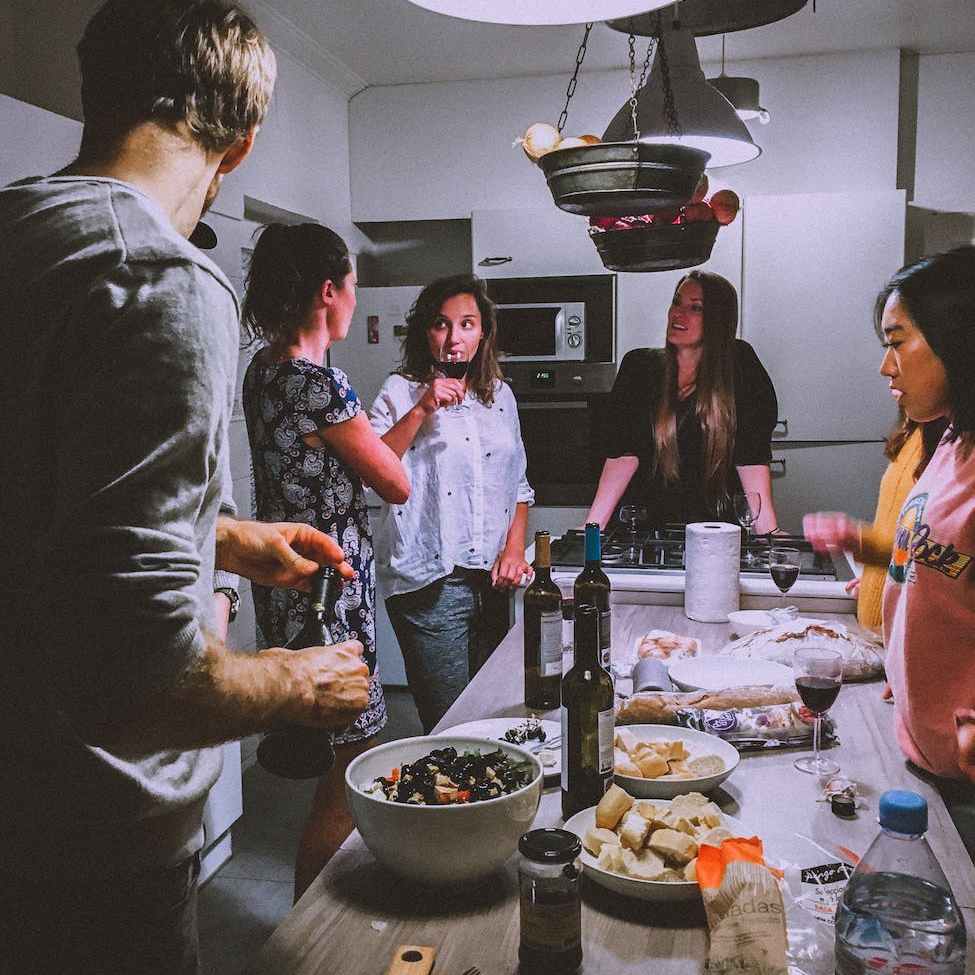 men and women standing infront of dining table